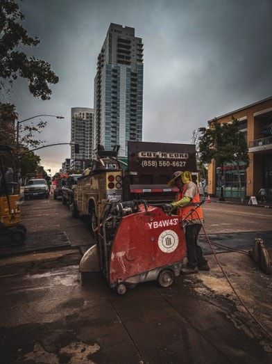 Worker operating concrete cutting equipment