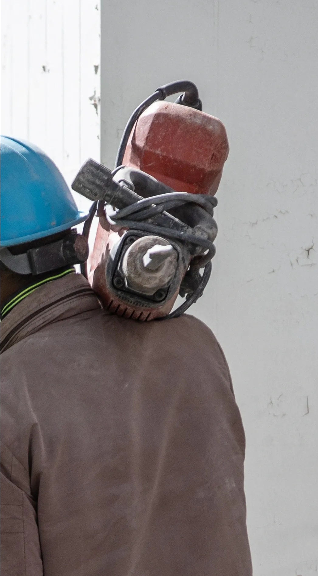 Construction worker operating concrete cutting equipment